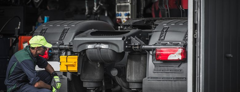 man inspecting rear of semi truck