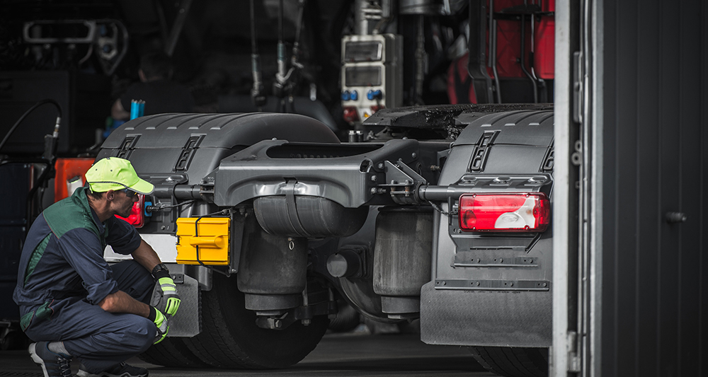 man inspecting rear of semi truck